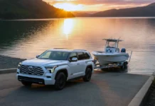 New Best 3-Row Hybrid SUVs for Towing and Family Road Trips (2026 Guide) A luxury 3-row hybrid SUV pulling a premium boat trailer up a boat ramp at sunset.